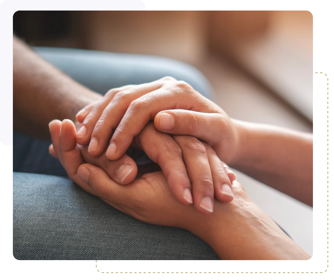 Two people holding hands in a comforting gesture.